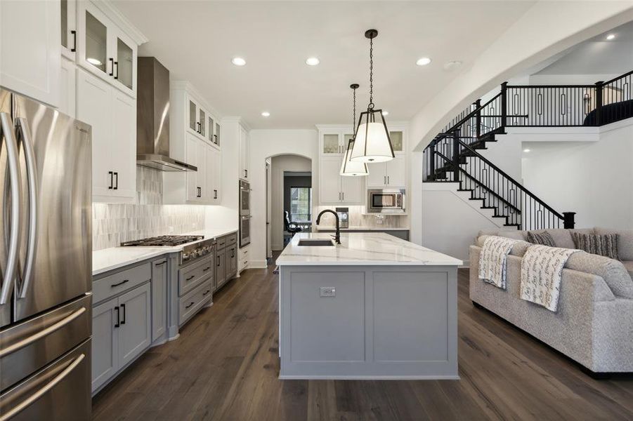 Kitchen featuring white cabinetry, appliances with stainless steel finishes, sink, and a center island with sink