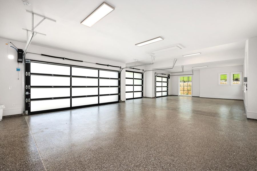 Three contemporary garage doors and a pristine epoxy floor await vehicles in this generous space.