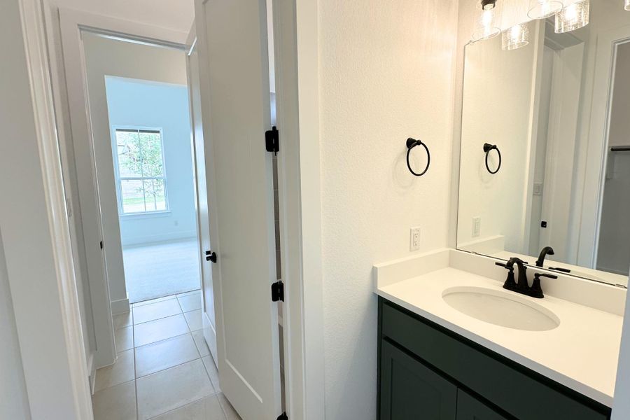 A well-appointed bathroom vanity features a broad mirror and modern fixtures.