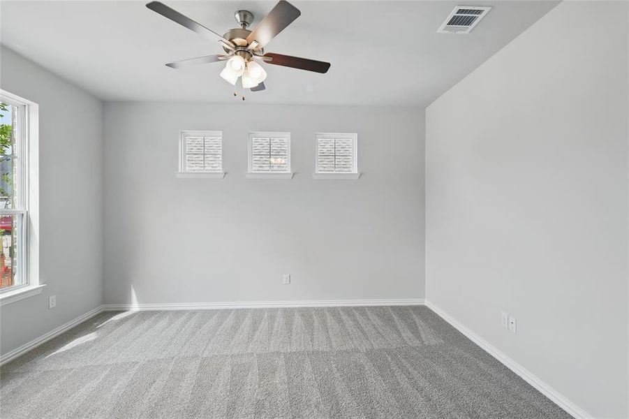 Spare room featuring ceiling fan and light carpet
