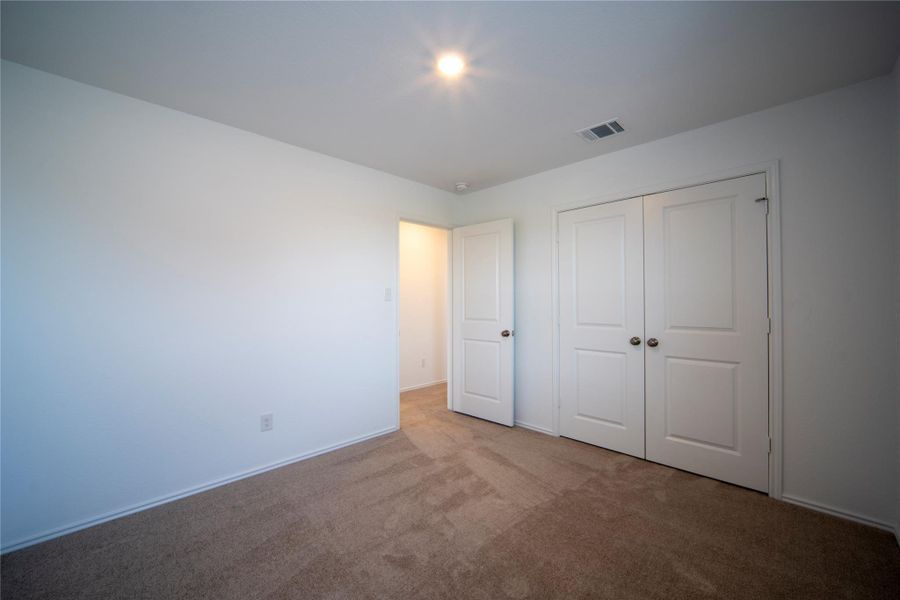Unfurnished bedroom featuring carpet floors and a closet