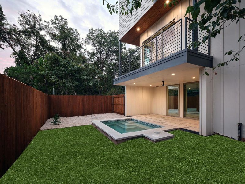 Fenced backyard featuring a balcony, a patio area, and an in-ground hot tub