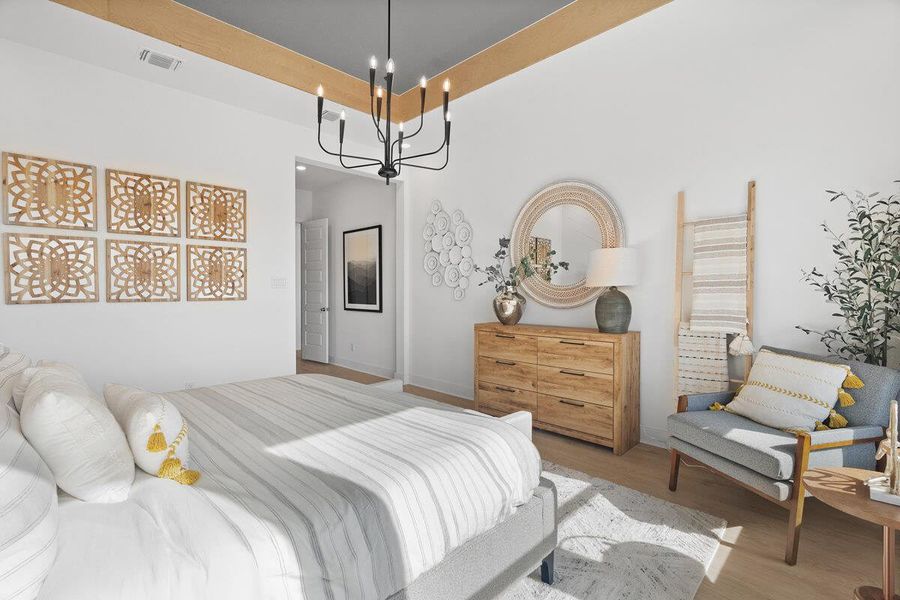 Bedroom featuring a chandelier, wood finished floors, and a high ceiling