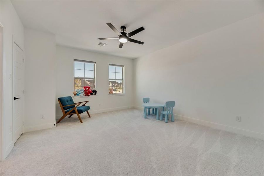 Unfurnished room featuring light carpet and a ceiling fan