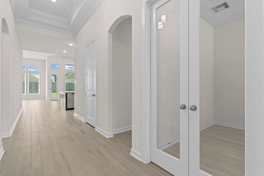 Stylish French glass panel doors open to a private home office/study, offering comfort, natural light, and a perfect retreat for work, reading, or quiet reflection.