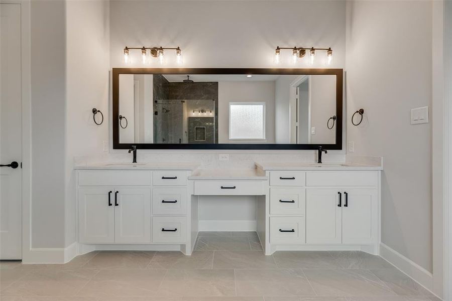 Bathroom with a shower stall and two vanities
