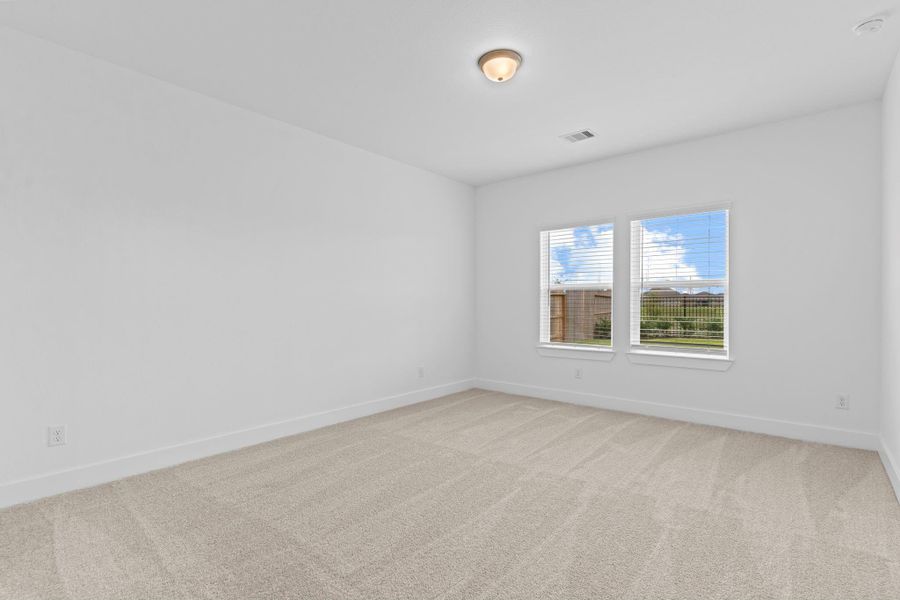 The serene primary suite offers a peaceful escape with soft carpet underfoot, and views of the private backyard with lakeview.