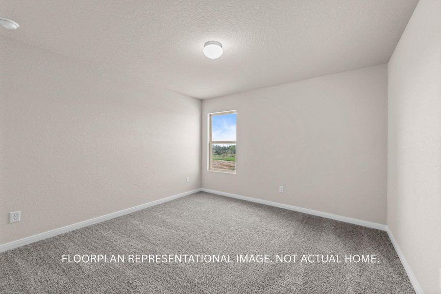 A well-proportioned bedroom offers comfort with plush carpeting and natural illumination through its window.
