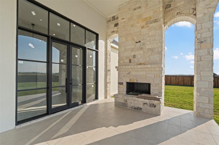 View of patio / terrace with an outdoor stone fireplace and french doors View of patio / terrace with an outdoor stone fireplace and french doors