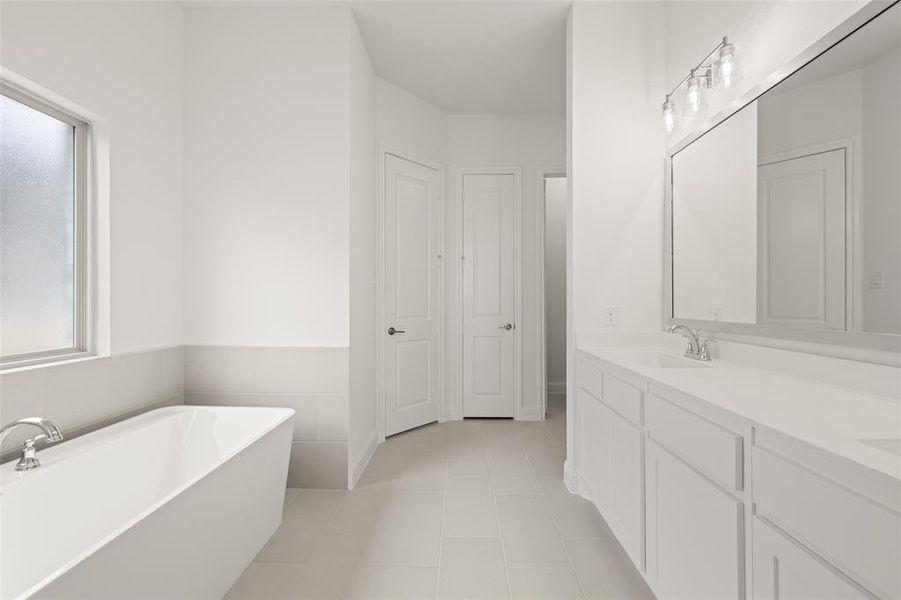 Full bath featuring a soaking tub, double vanity, and tile patterned flooring Full bath featuring a soaking tub, double vanity, and tile patterned flooring