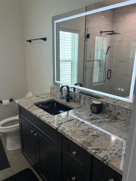 Bathroom featuring vanity and a shower stall