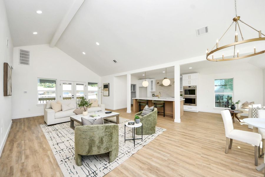 An airy, open living space where vaulted ceilings and natural light set a calming tone. Light wood floors and thoughtfully styled seating invite you to unwind, while the clean, modern layout makes the room feel both spacious and intimate.