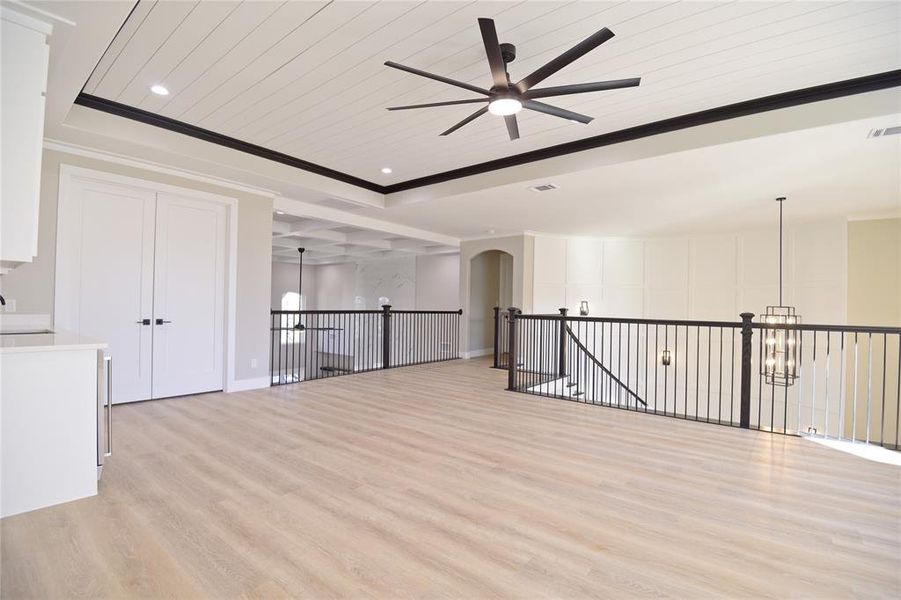 Spare room with a raised ceiling, ornamental molding, light hardwood / wood-style flooring, and wooden ceiling