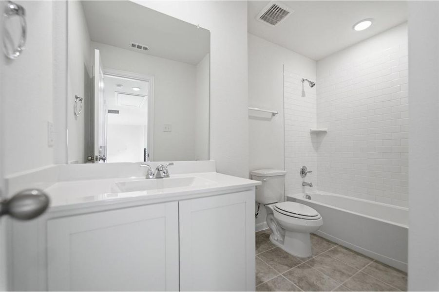 Bathroom featuring a white vanity with integrated sink, chrome faucet, and a large wall-mounted mirror