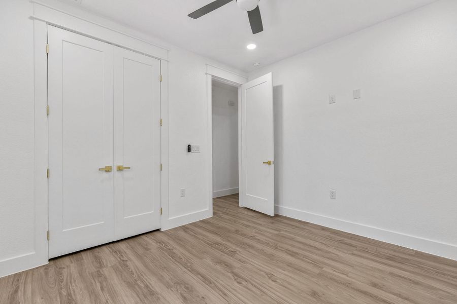 Unfurnished bedroom featuring light wood-style flooring, a closet, a ceiling fan, and recessed lighting