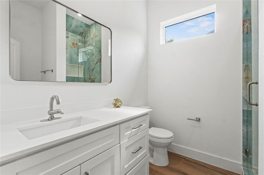 Full bathroom with dark wood-type flooring, vanity, and a marble finish shower