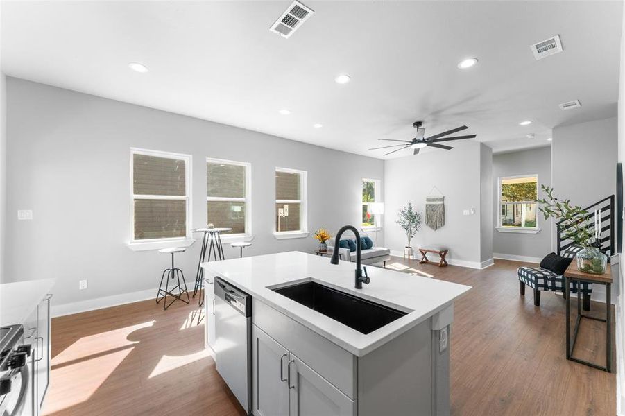 Kitchen with gray cabinetry, recessed lighting, dark wood-style floors, appliances with stainless steel finishes, and open floor plan