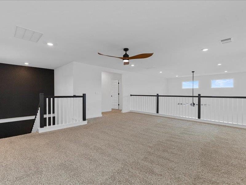 Spare room featuring light colored carpet, a ceiling fan, and recessed lighting