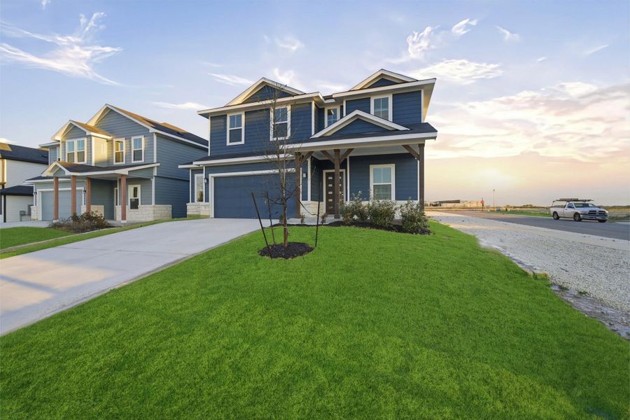 Craftsman-style house featuring an attached garage, concrete driveway, a front lawn, and a porch