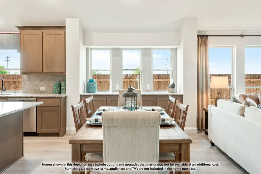 Open-concept dining area with wood table, adjacent kitchen with brown cabinets and light wood floors Open-concept dining area with wood table, adjacent kitchen with brown cabinets and light wood floors