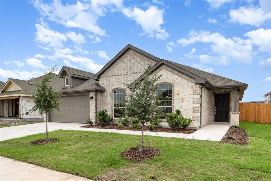 View of front of property featuring a garage and a front lawn