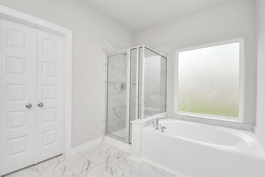 The primary en-suite has a soaking tub to give you that spa experience. The large privacy window allow lots of nature light in the space.