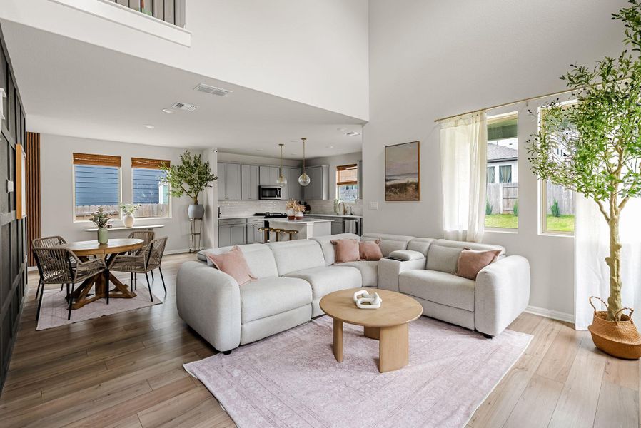 Living area with light wood-style floors, plenty of natural light, recessed lighting, and a high ceiling
