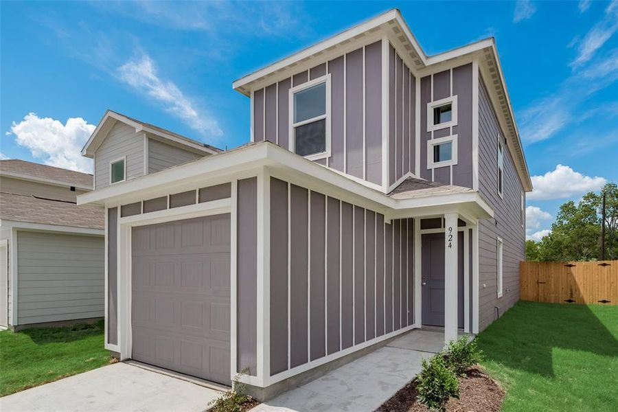 View of front facade with a garage and a front lawn