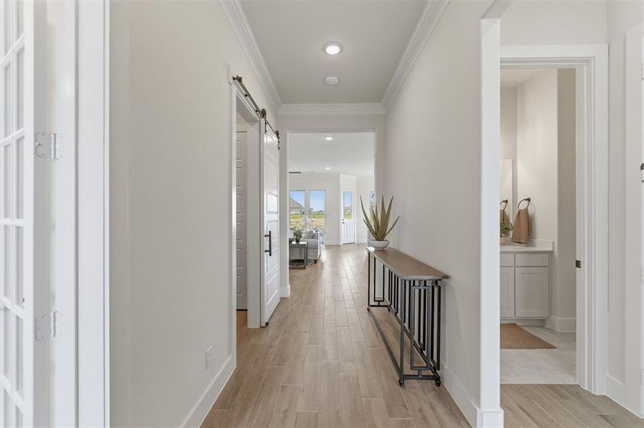 Hallway featuring wood-finish flooring and crown molding