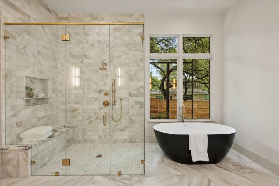 A freestanding soaking tub complements a spacious, glass-enclosed shower with a built-in bench. A freestanding soaking tub complements a spacious, glass-enclosed shower with a built-in bench.