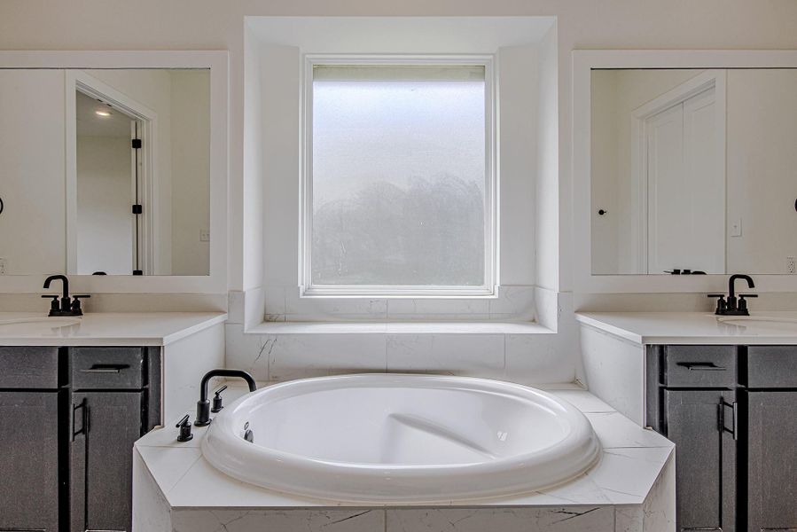 Relax and recharge in the soaking tub, perfectly positioned beneath a large window for a bright, spa-inspired atmosphere Relax and recharge in the soaking tub, perfectly positioned beneath a large window for a bright, spa-inspired atmosphere