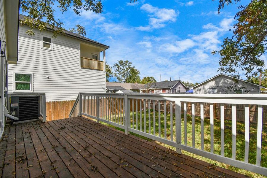 This is a single-story home with a spacious, fenced backyard, featuring a large deck and mature tree, offering both privacy and outdoor living space.