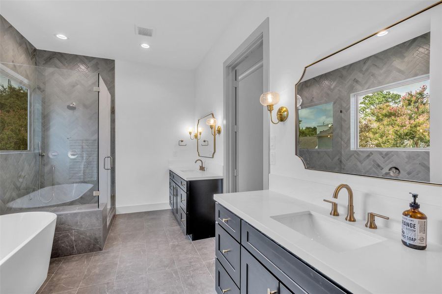 Primary bathroom features a separate shower, soaking tub, and dual sinks, complemented by modern fixtures and finishes for a polished look.