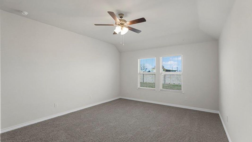 Room featuring two windows with blinds, a ceiling fan with light fixture, gray carpet, and light-toned walls