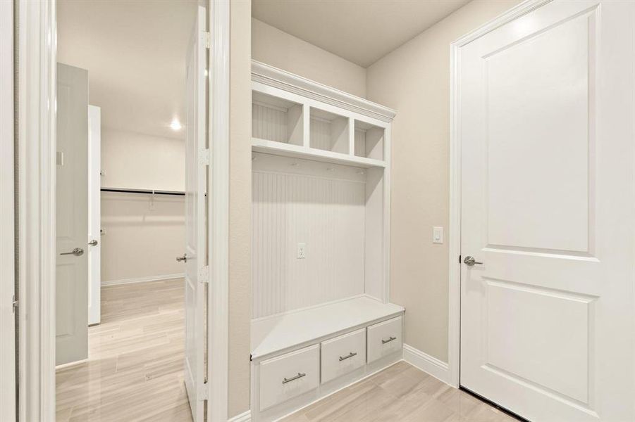 Mudroom featuring light wood finished floors and baseboards