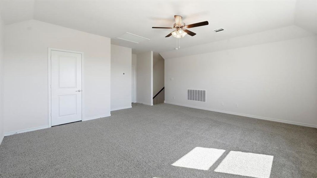 Bonus room with carpet flooring, attic access, lofted ceiling, and a ceiling fan Bonus room with carpet flooring, attic access, lofted ceiling, and a ceiling fan