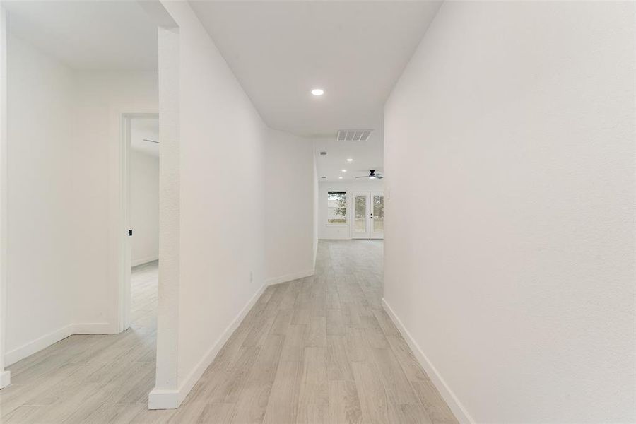 Corridor with light hardwood / wood-style flooring