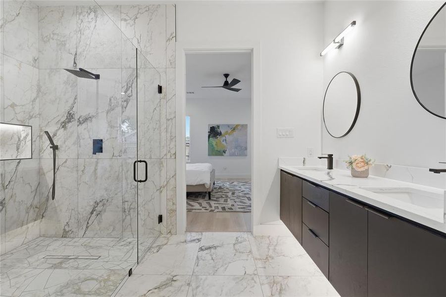 Walk-in shower with full-height marble-look tile, frameless glass enclosure, and matte black fixtures