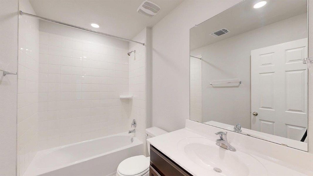 Bathroom featuring a full-size bathtub with white subway tile surround, chrome fixtures, and a vanity with an integrated sink and spacious counter Bathroom featuring a full-size bathtub with white subway tile surround, chrome fixtures, and a vanity with an integrated sink and spacious counter