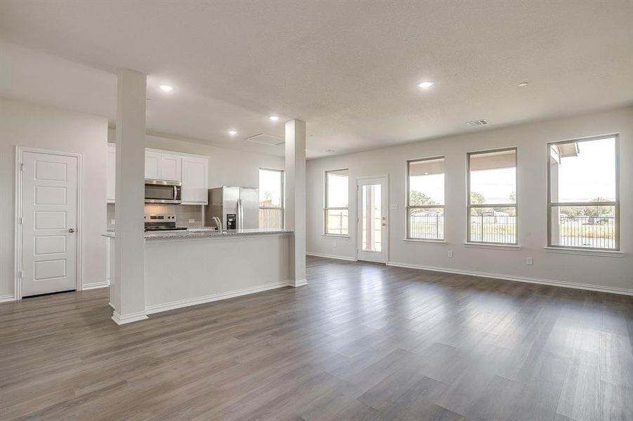 Unfurnished living room with dark wood-style flooring and recessed lighting