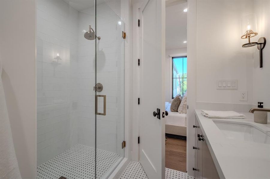 Bathroom with a shower stall, vanity, connected bathroom, and recessed lighting Bathroom with a shower stall, vanity, connected bathroom, and recessed lighting