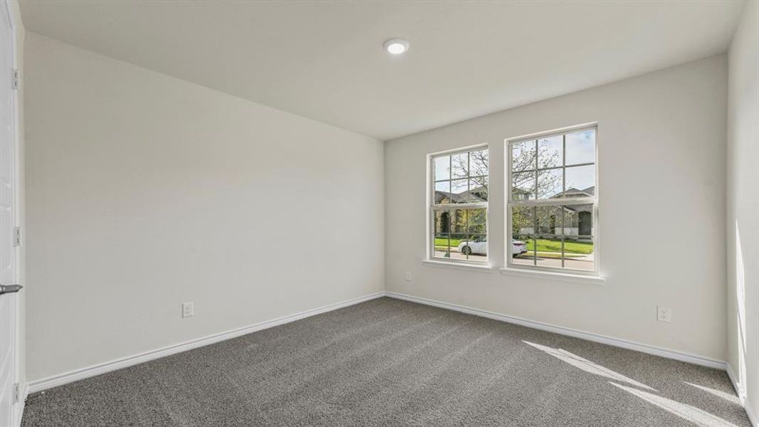 Spacious room featuring two large windows with grid detailing, recessed lighting, and grey carpet flooring