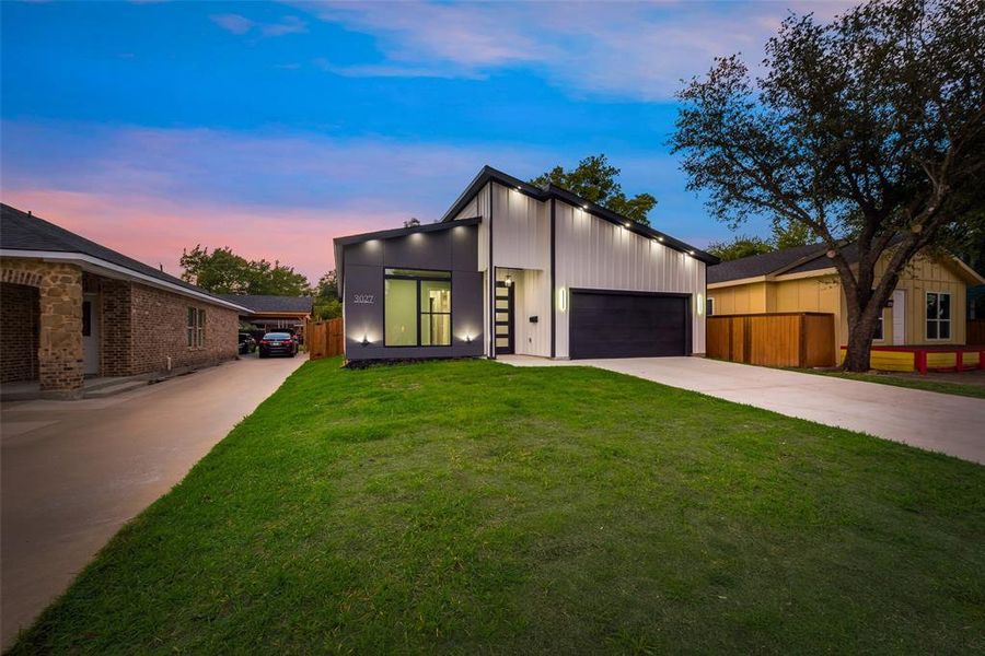 View of front of property featuring a yard and a garage