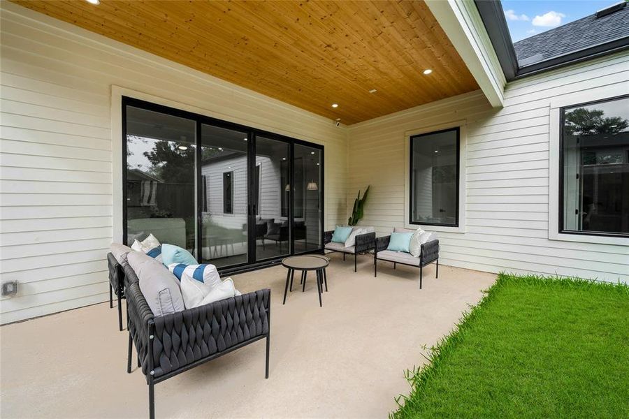 The property features an expansive outdoor patio with a wooden ceiling and recessed lighting, offering ample space for entertaining