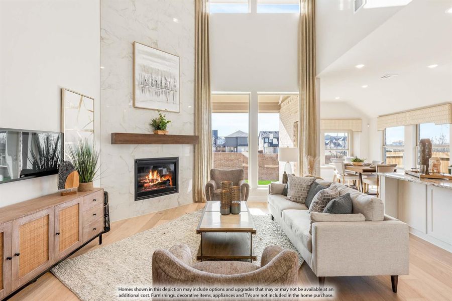 Living room with two-story ceiling, marble fireplace, hardwood floors, and large windows with backyard view Living room with two-story ceiling, marble fireplace, hardwood floors, and large windows with backyard view