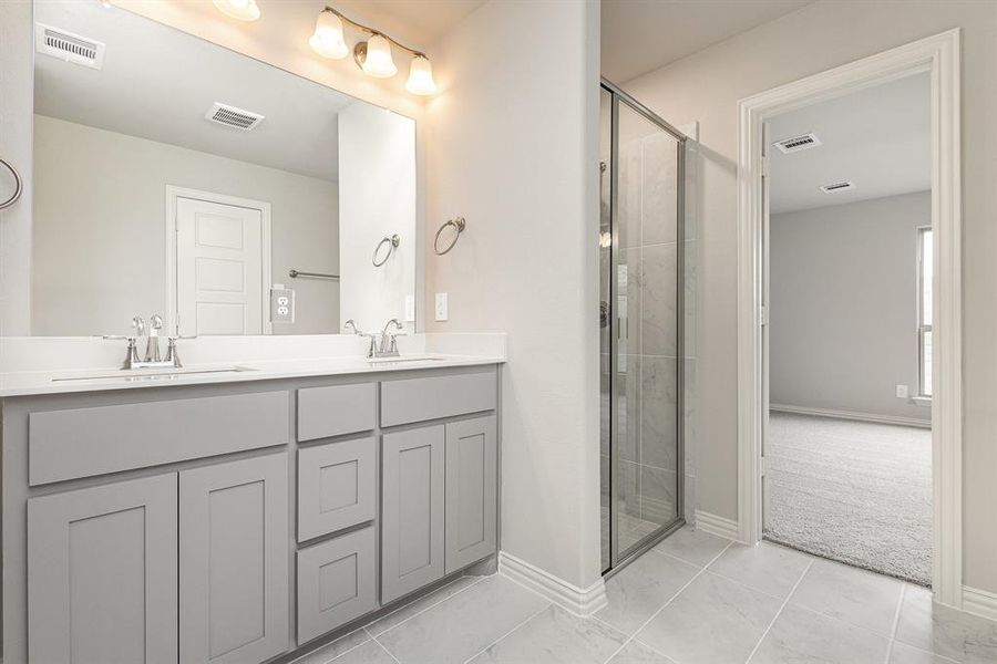 Bathroom featuring vanity, tile patterned floors, and an enclosed shower