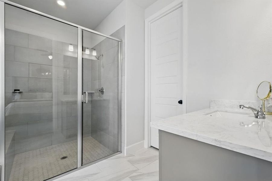 Full bathroom featuring a shower stall, vanity, and marble finish floor