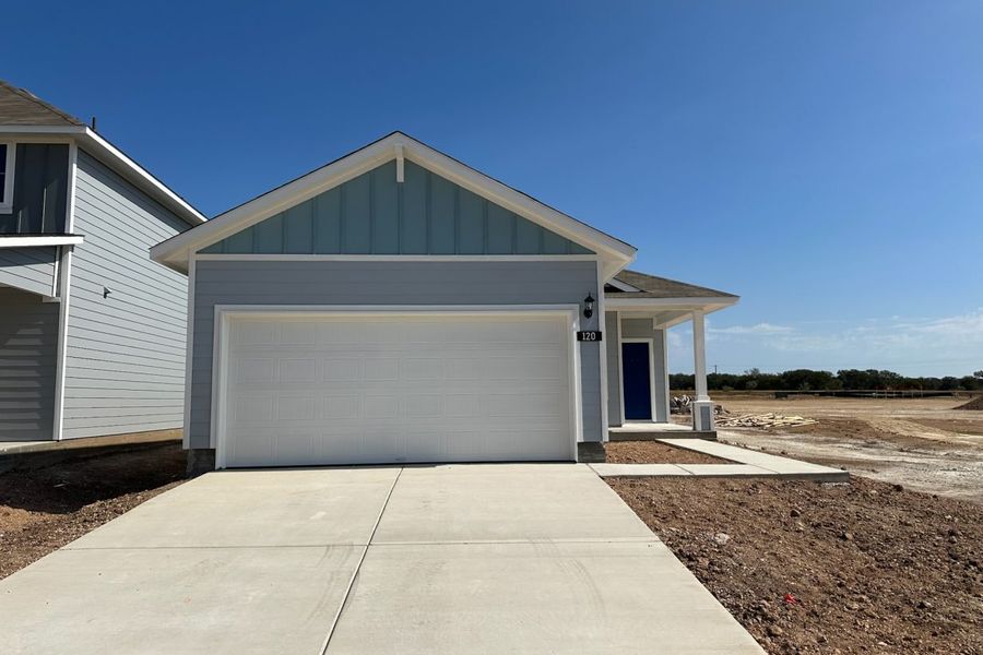 Image of one story blue home with white trim and garage and blue front door Image of one story blue home with white trim and garage and blue front door