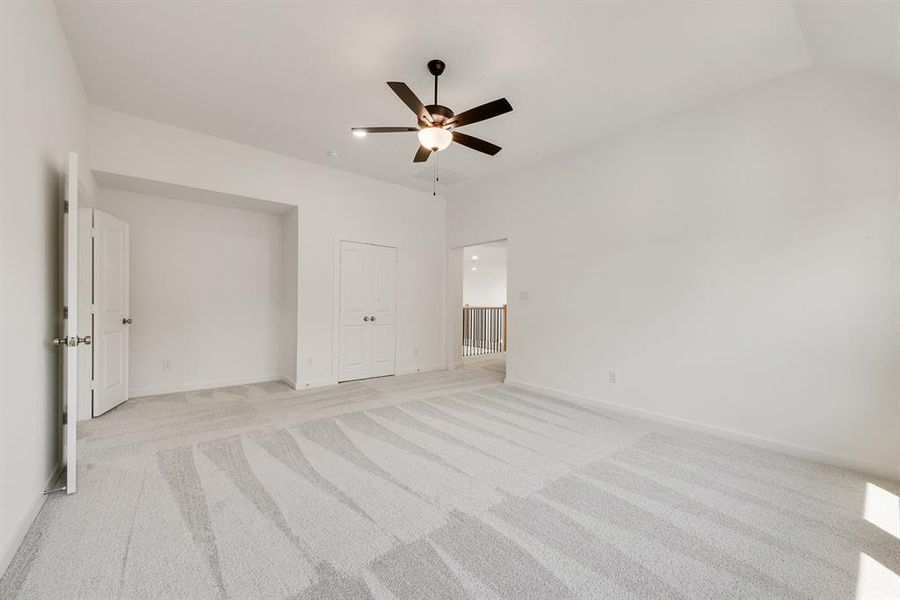 Unfurnished bedroom with light carpet and a ceiling fan Unfurnished bedroom with light carpet and a ceiling fan