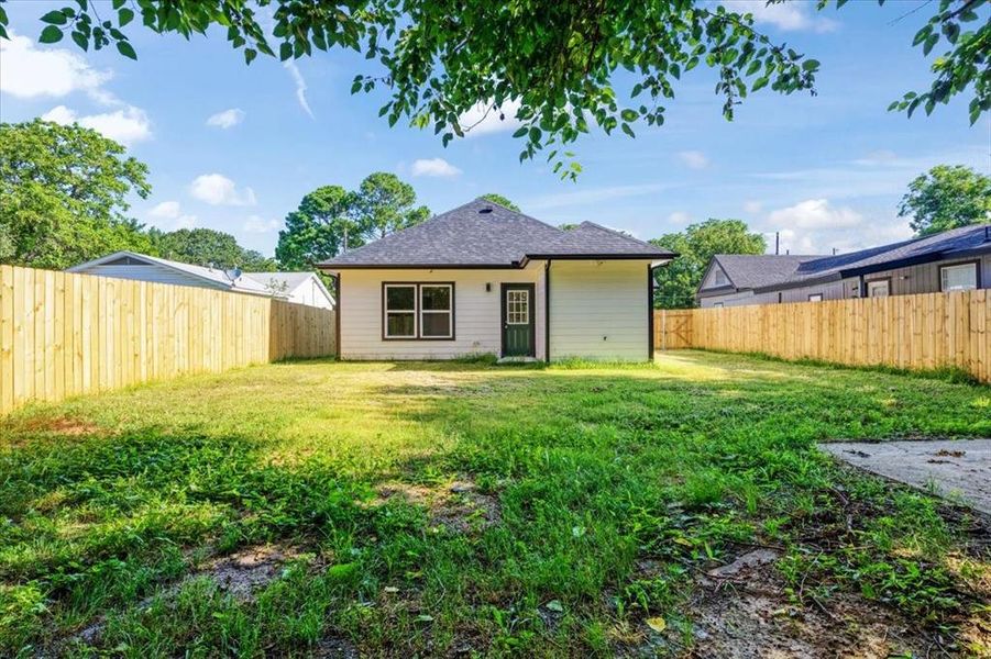 Rear view of property featuring a lawn